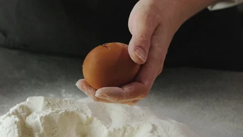 The cook cracks the egg and adds it to the flour Vídeo Stock 176548732