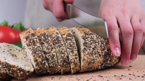 Cook Cut Bread With a Knife on a Board. on the Table Lay the Tomatoes, Lettuce 動画素材 61882578