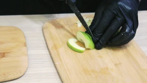 The cook cuts an apple with a kitchen knife. Stock Footage 171650001