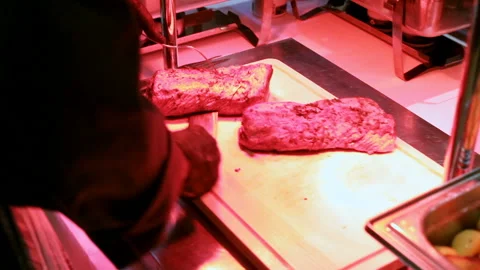 The cook cuts a beef steak with a knife, hands cut the meat with a knife Stock Footage 145855418