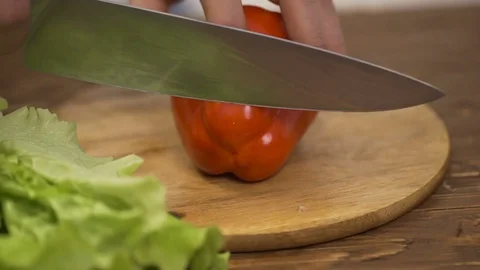 A cook cuts a bell pepper on a cutting board in a kitchen Video stock 71381793