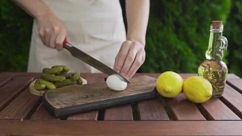 The cook cuts boiled egg in a half on the wooden board outdoors, cooking outside Video stock 77577935