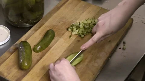 Cook cuts the canned cucumbers on the wooden board Stock Footage
