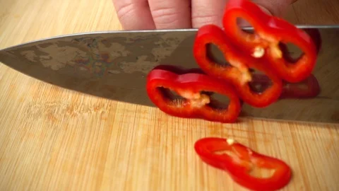 The cook cuts the capi pepper with a knife. Slow motion.	 Stock-Footage 128499016