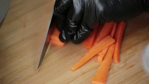 Cook cuts carrots with a sharp knife on a cutting board Stock Footage 127205075
