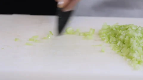 The cook cuts celery stalks with a large kitchen knife into small slices. Stock Footage 274069987