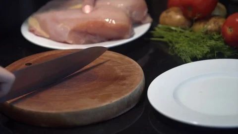 The cook cuts the chicken breast in half, raw chicken, chef cooks chicken Stock Footage 82591909
