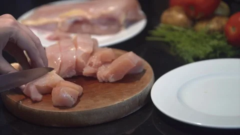 The cook cuts the chicken breast in half, raw chicken, chef cooks chicken Stock Footage 82592090