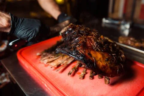 The cook cuts the cooked meat. Stock-Fotos