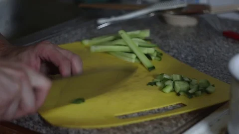 Cook cuts cucumbers in the kitchen Stock Footage 117623546