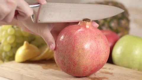 The cook cuts the fruit of pomegranate Stock Footage 84829029
