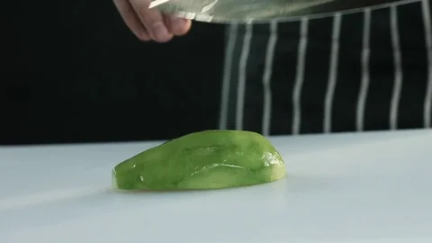 Cook cuts half of the avocado into slices. Slowmotion Stock Footage 80595618