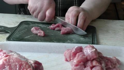 The cook cuts it into pieces of raw meat Stock Footage 136624188