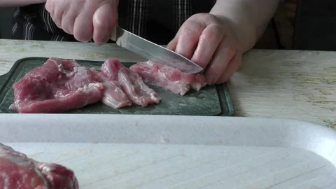 The cook cuts it into pieces of raw meat 스톡 동영상 136625309