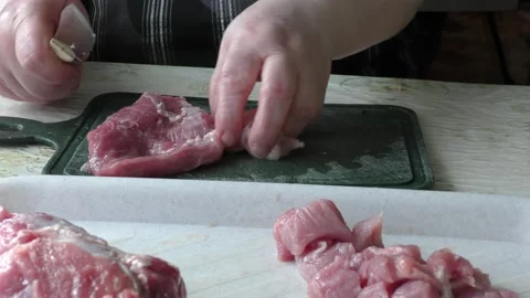The cook cuts it into pieces of raw meat Stock Footage 136625659