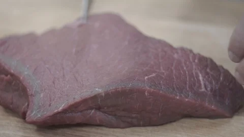 The cook cuts a large piece of meat into small portions. Video stock 106631108