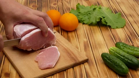 Cook cuts a large piece of selected meat on a cutting board, close up. Next to Stock Footage 202298715