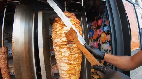 A cook cuts meat to make shawarma, gyros, doner kebab. Stock Footage 113970265