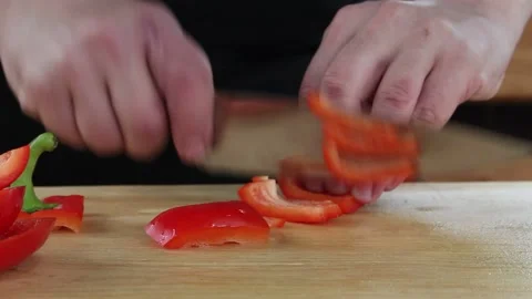 The cook cuts the pepper. slicing vegetables on a Board Stock Footage 134197214