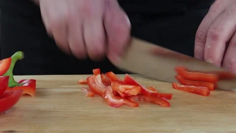 The cook cuts the pepper. slicing vegetables on a Board Stock Footage 134197221