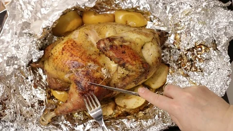 Cook cuts a piece of fried or roasted chicken for sampling.  Stock Footage 121330754