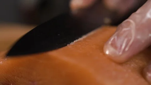 The cook cuts a piece of red fish with a knife Stock Footage 124209762