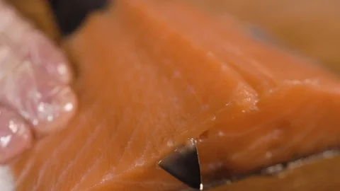 The cook cuts a piece of red fish with a knife Stock Footage 124210354