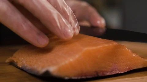The cook cuts a piece of red fish with a knife Stock Footage 124210736