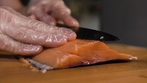 The cook cuts a piece of red fish with a knife Stock Footage 124210811