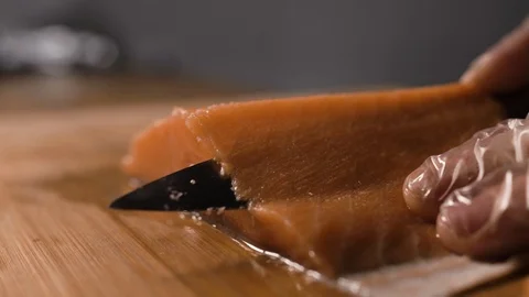 The cook cuts a piece of red fish with a knife Stock Footage 124211803