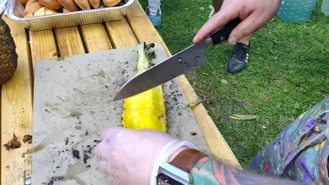 The cook cuts a pineapple with a large knife Stock Footage 156802093