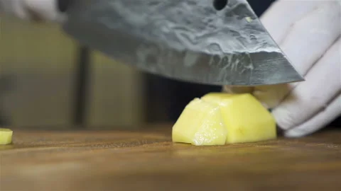 Cook cuts potato .Close up scene Stock Footage 169744624