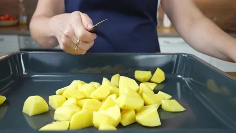 The cook cuts the potatoes into a baking sheet. the process of roasting Stock Footage 164333856