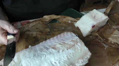 The cook cuts raw cod fish into pieces Stock Footage 180581204