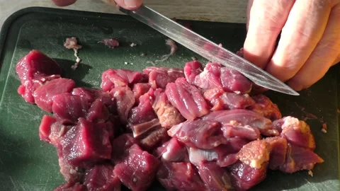 The cook cuts raw deer meat with a knife. healthy food concept Видео 151020853