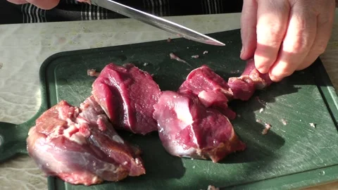 The cook cuts raw deer meat with a knife. healthy food concept Stockbeeldmateriaal 151021910