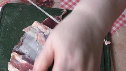The cook cuts raw deer meat with a knife.  healthy food concept Stock Footage 154050396