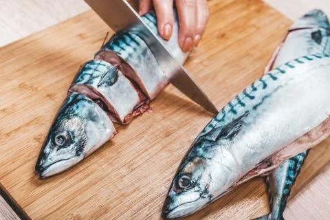 Cook cuts raw mackerel fish Stock Photos
