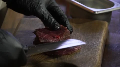 Cook cuts raw meat on a wooden board Video stock 148314853