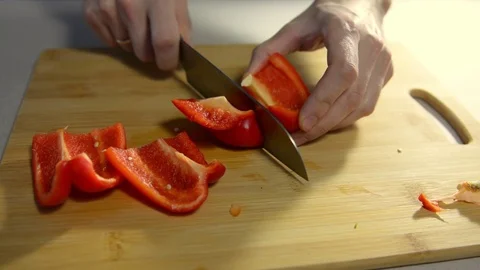 Cook cuts red bell pepper on a wooden board. Stock Footage 123363613