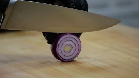 Cook cuts red onion with a sharp knife on a cutting board Stock Footage 127202480