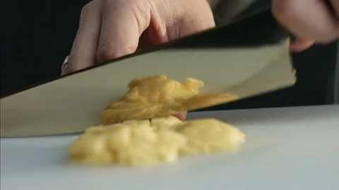 The cook cuts a ripe mango with a knife into pieces that are reflected on the Stock Footage 79900740