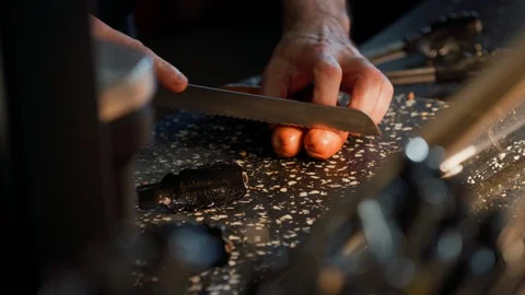 The cook cuts sausages by sharp knife on black stone board, fast food cooking 스톡 동영상 115963293