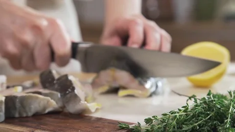 The cook cuts sturgeon on the kitchen board, cooking fish meals, cuisine with Stock Footage 79060357