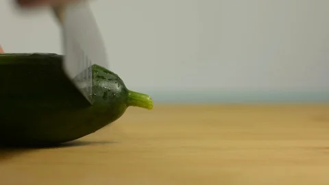 The cook cuts the tail of the cucumber. Fresh green cucumber Stock Footage 128917708