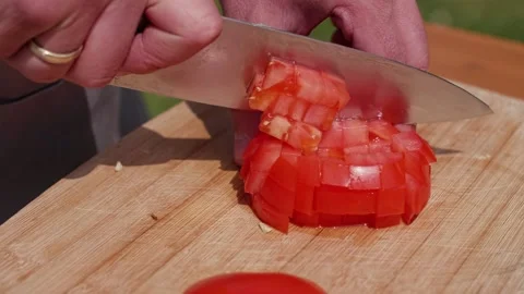 A cook cuts a tomato with a kitchen knife Stock Footage 228039025