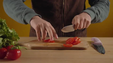 Cook cuts tomato with a large kitchen knife. Stock Footage 171592909
