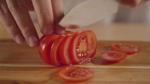 Cook cuts tomato with a large kitchen knife. Stock Footage 171595658