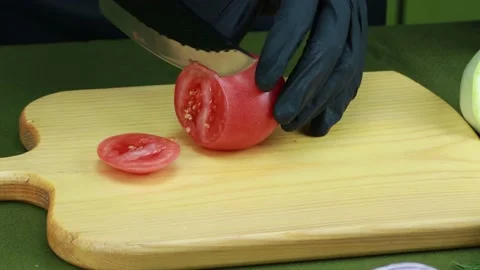The cook cuts the tomato into slices with a very sharp knife Stock Footage 159762573