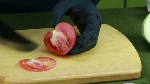 The cook cuts the tomato into slices with a very sharp knife Stock Footage 159763023